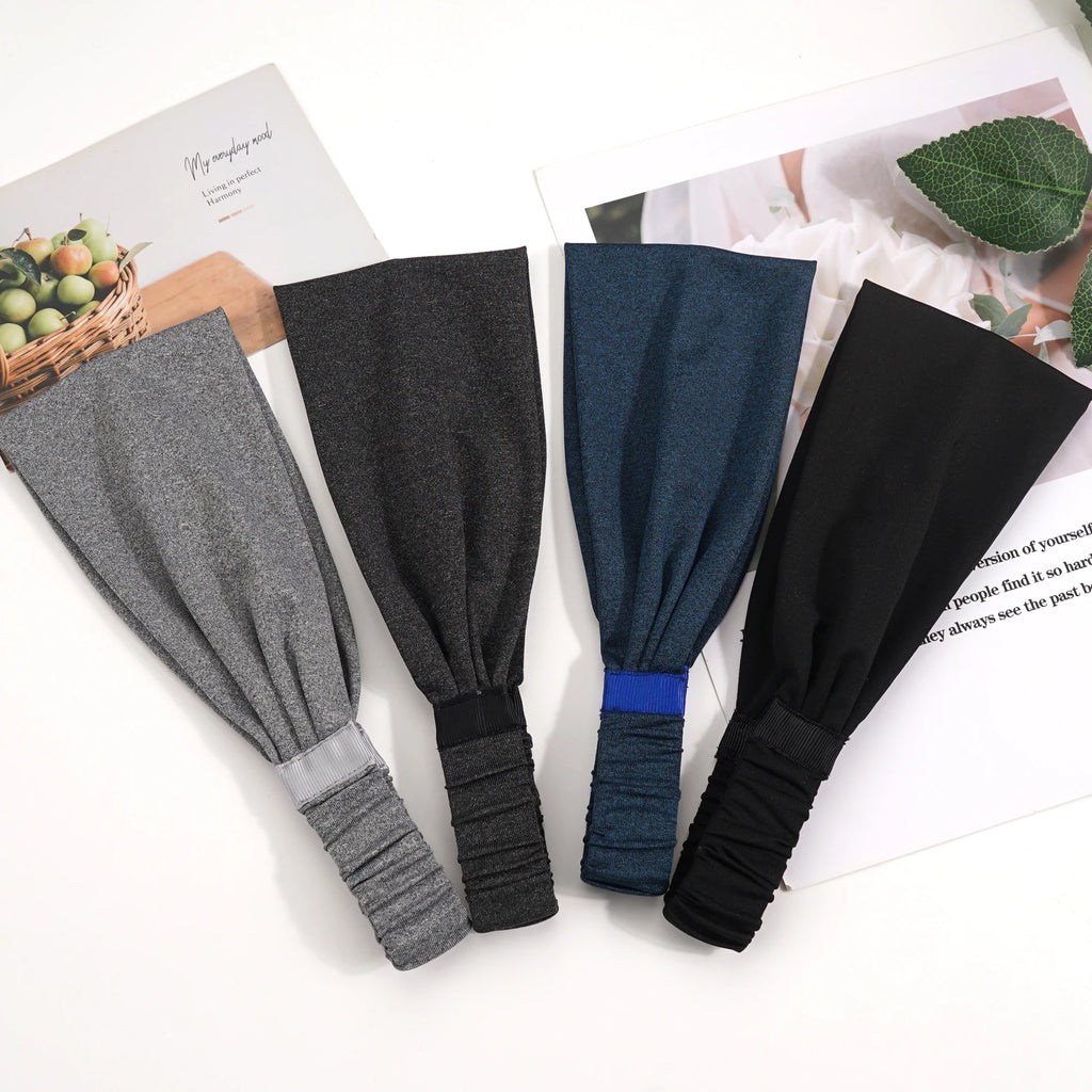 Four stretchy fabric headbands in grey, charcoal, navy blue, and black, each featuring an elasticated back detail.