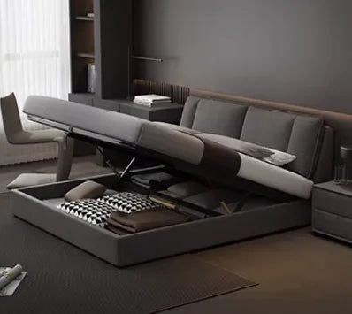 Modern, dark grey upholstered double bed with a lift-up base for integrated storage in a contemporary bedroom.