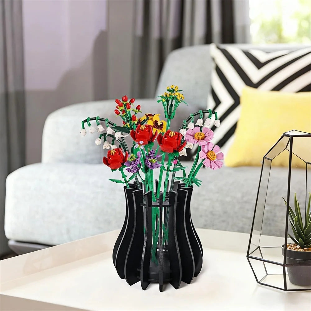 Artificial colourful wildflower bouquet in a modern, slatted black vase on a white tabletop.