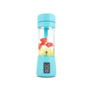 Portable light blue personal blender with a clear cup containing fruit pieces and a power button on the base.