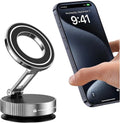 Silver and black magnetic phone stand with an adjustable arm, shown next to a smartphone being held by a hand.