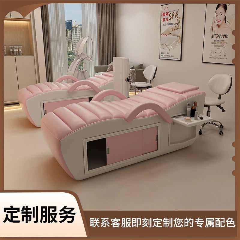 Professional pink and white massage bed featuring integrated storage cabinets and an attached side tray for accessories.