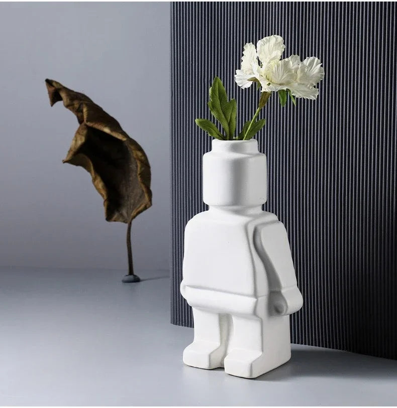 White ceramic vase shaped like a playful toy character, featuring a smooth matte finish and a flower holder head.