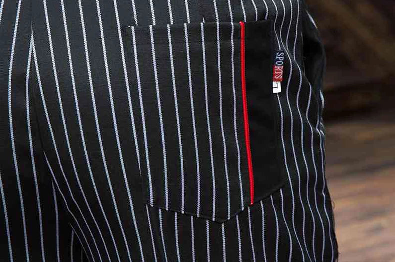 Black chef trousers with white pinstripes, featuring a back pocket with a vertical red stripe detail.
